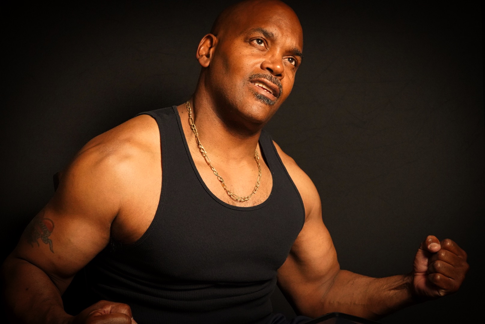 Lucius Alston demonstrating strength in a black training tank